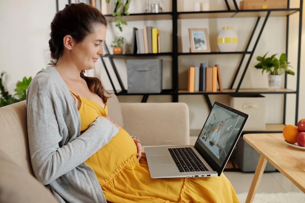 Expectant parent learning from home on a laptop